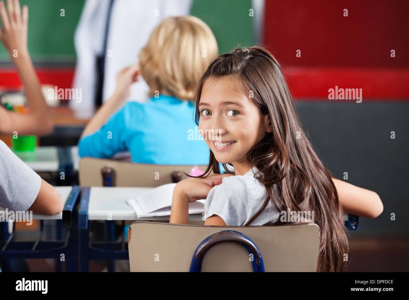 Schoolgirl Sitting At Desk In Classroom Stock Photo - Alamy