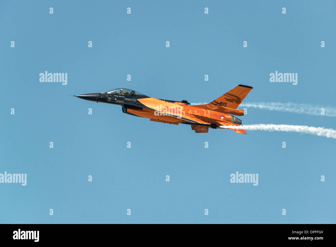 F-16 fighter jet of the Royal Netherlands Air Force demonstration team in it's striking orange livery demonstrates at RIAT Stock Photo