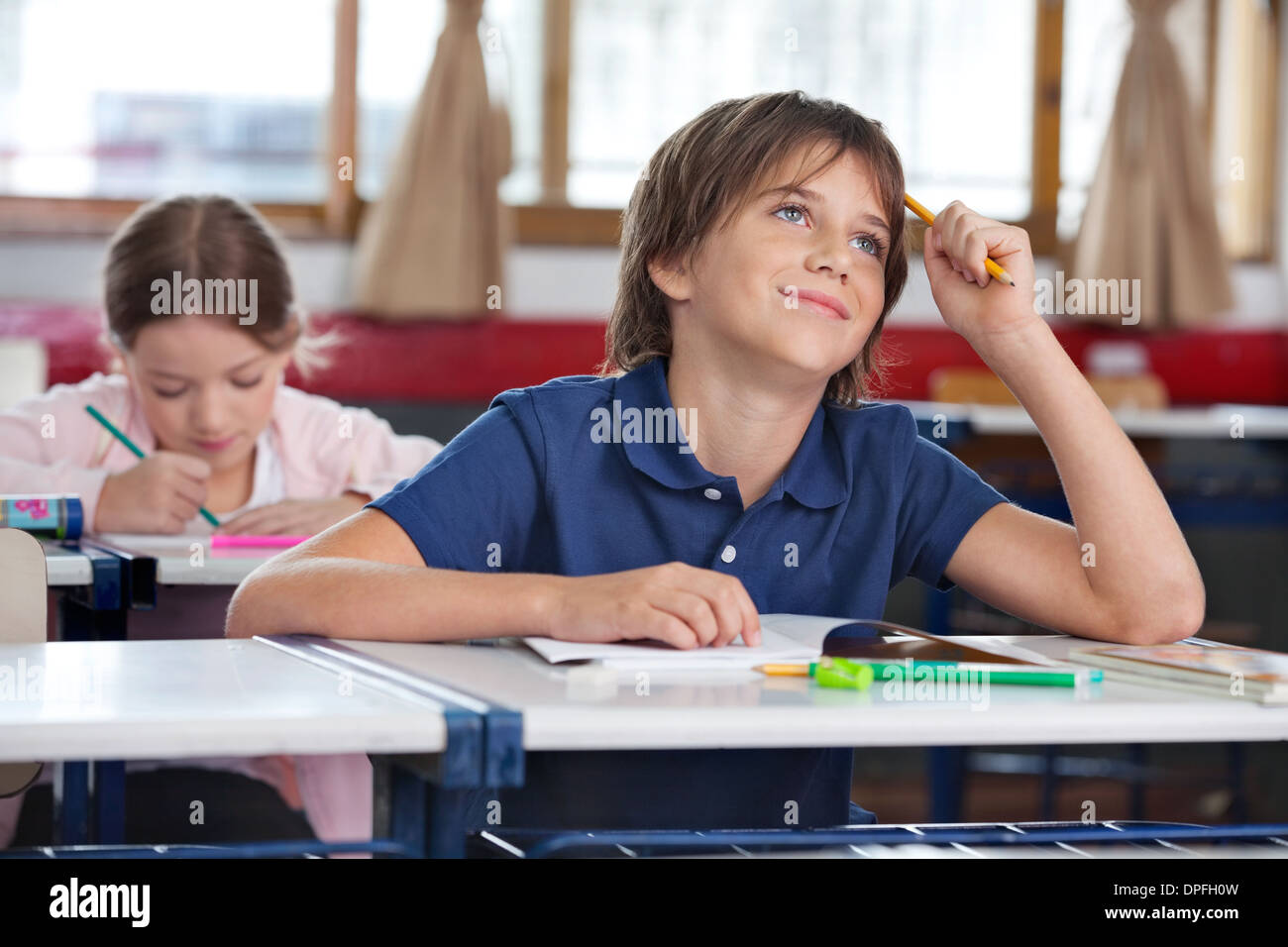 Little Boy Smiling While Looking Up In Classroom Stock Photo - Alamy