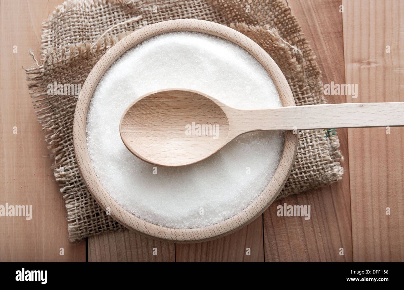 sugar in a wooden bowl on wooden table, close up Stock Photo