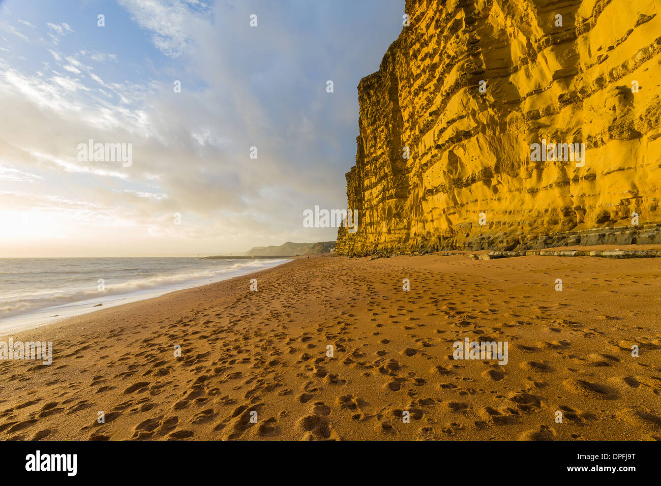 The late afternoon winter sun lights up the red sandstone cliffs at West Bay, Dorset, on the Jurassic Coast. November 2013. Stock Photo