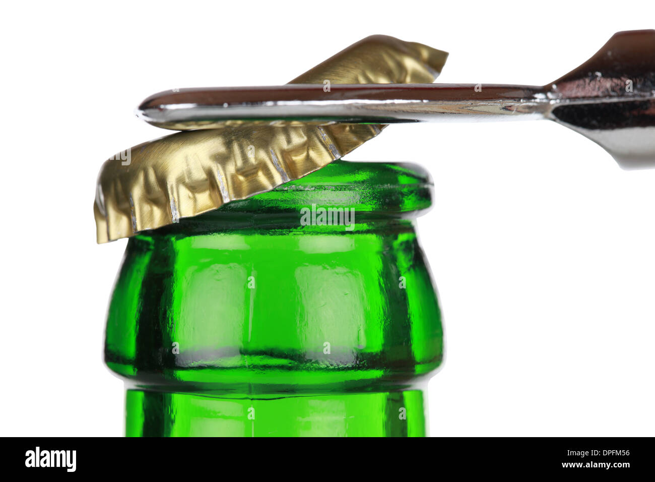 Opening a green beer bottle with an opener, isolated on white background Stock Photo