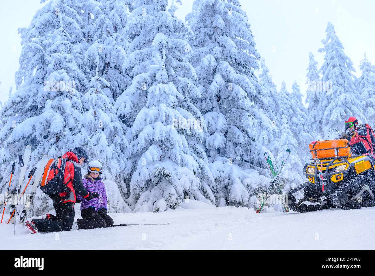 Ski patrol helping woman with broken arm rescue quad Stock Photo Alamy