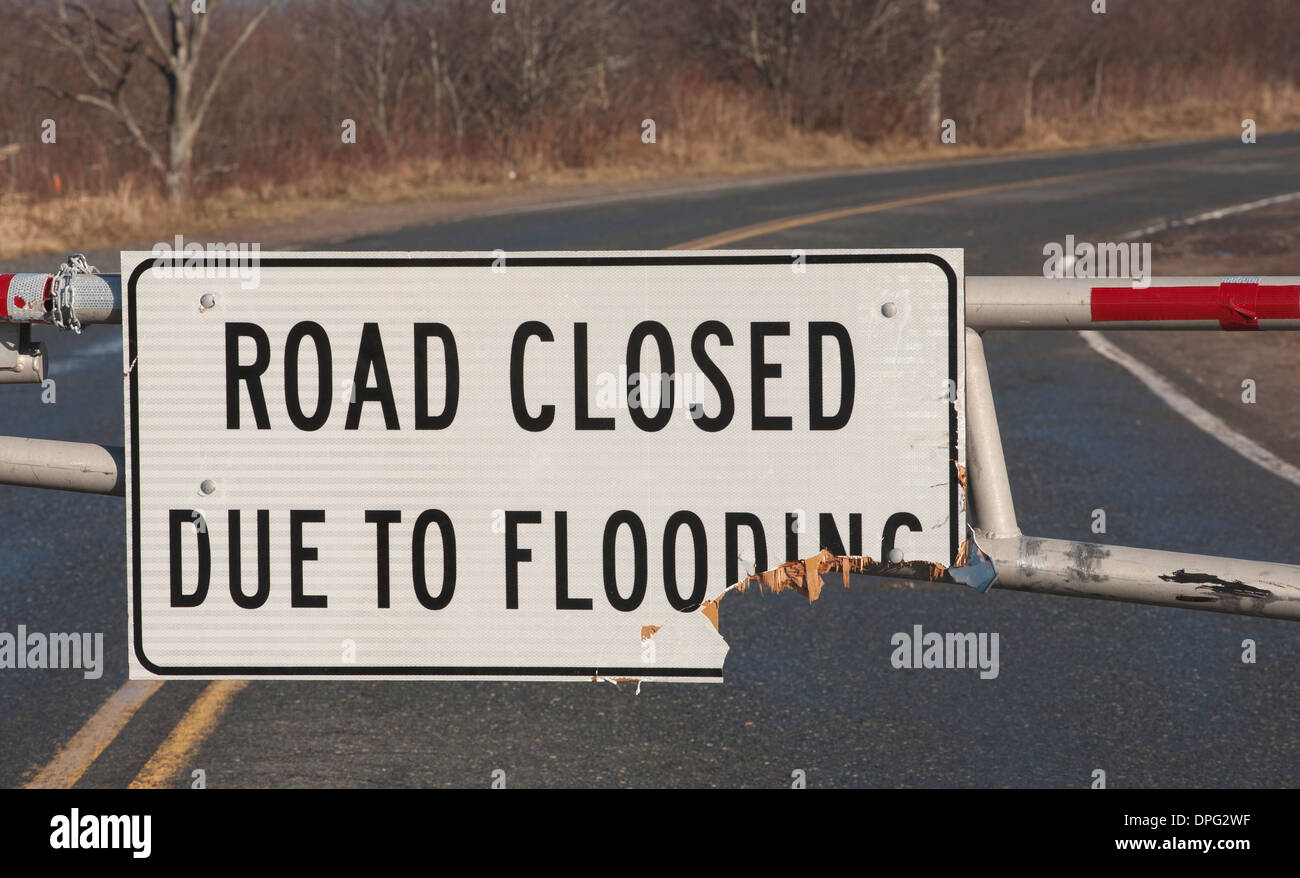 Broken road closed due to flooding sign Stock Photo