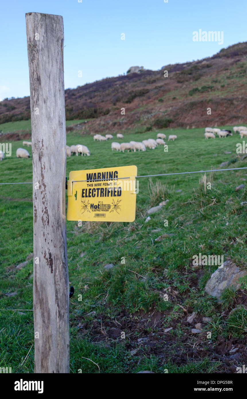 Sign warning of electrified fence along the south west coastal path in devon Stock Photo