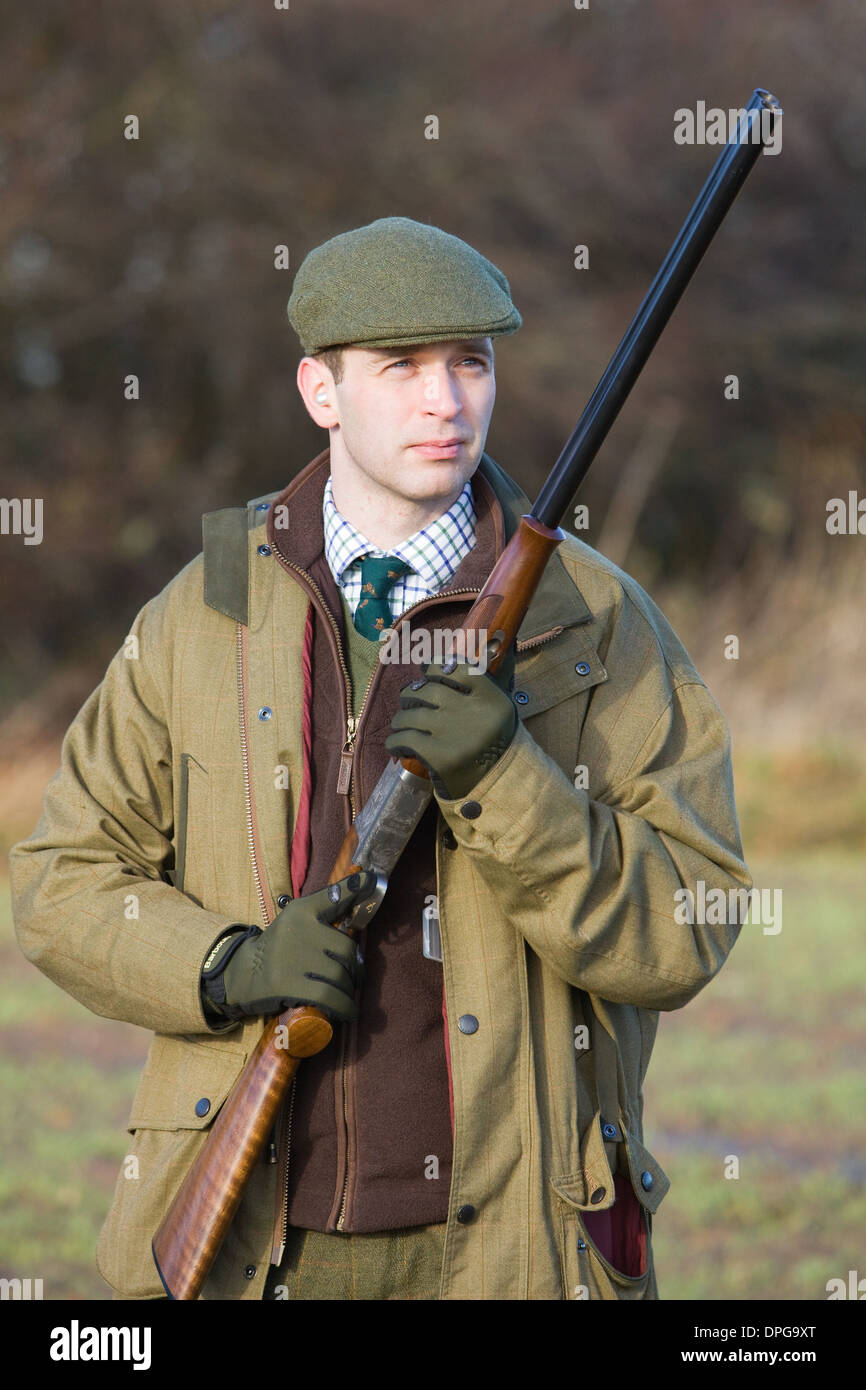 A man with a shotgun on a pheasant shoot in England Stock Photo