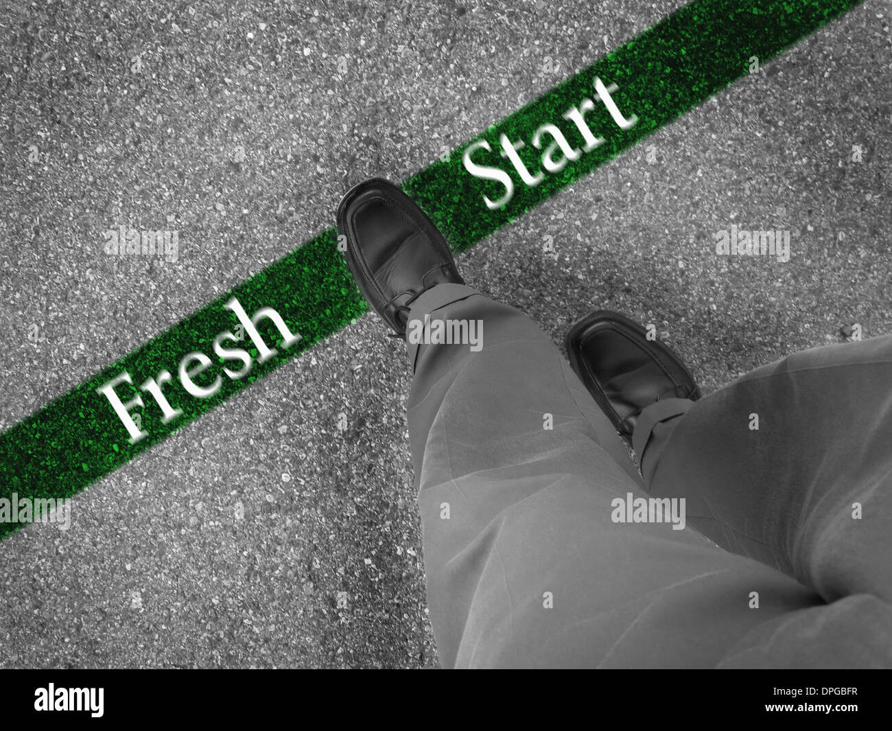 Man walking across a green line with words fresh start Stock Photo