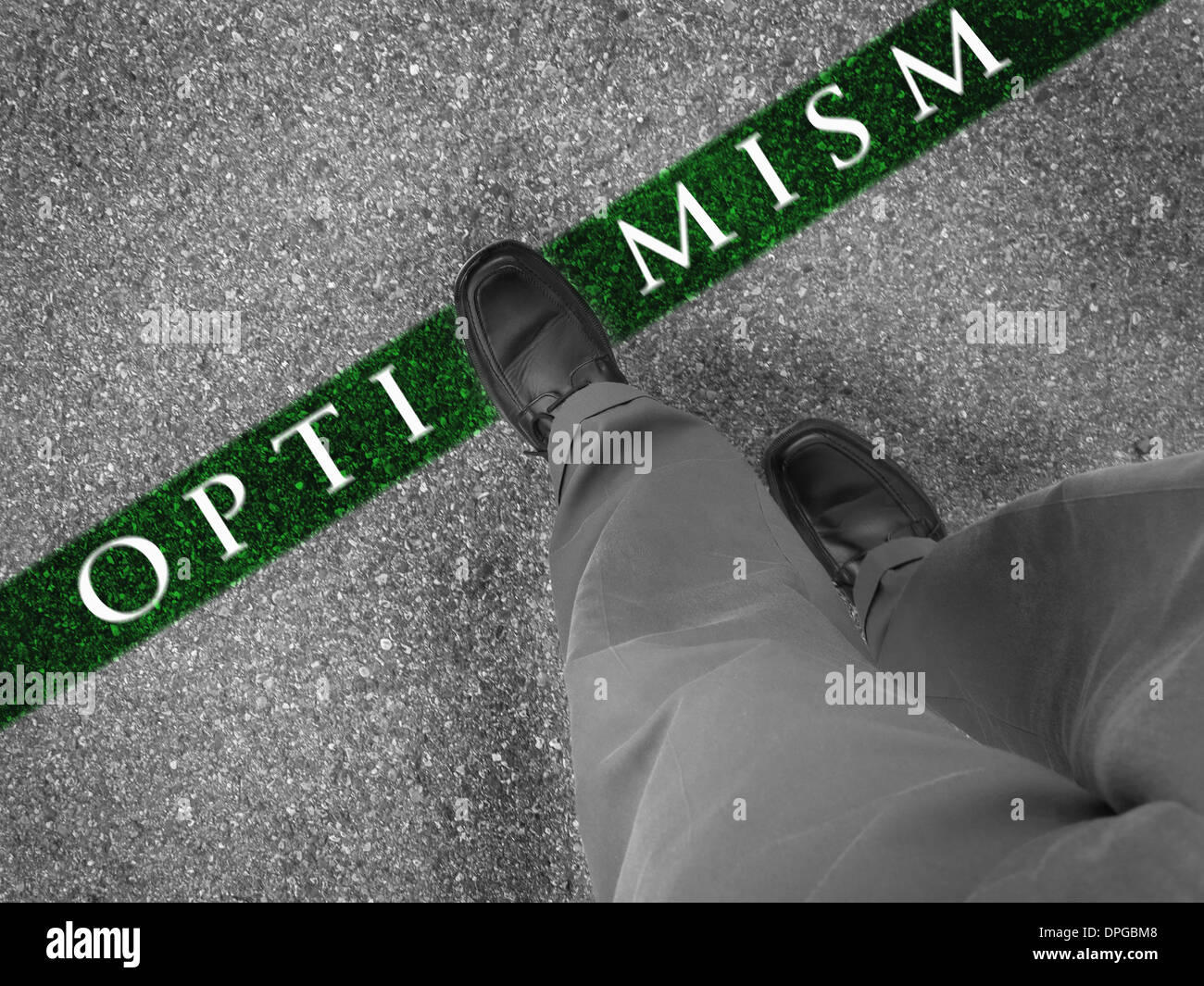 Man walking across a green line with words optimism Stock Photo