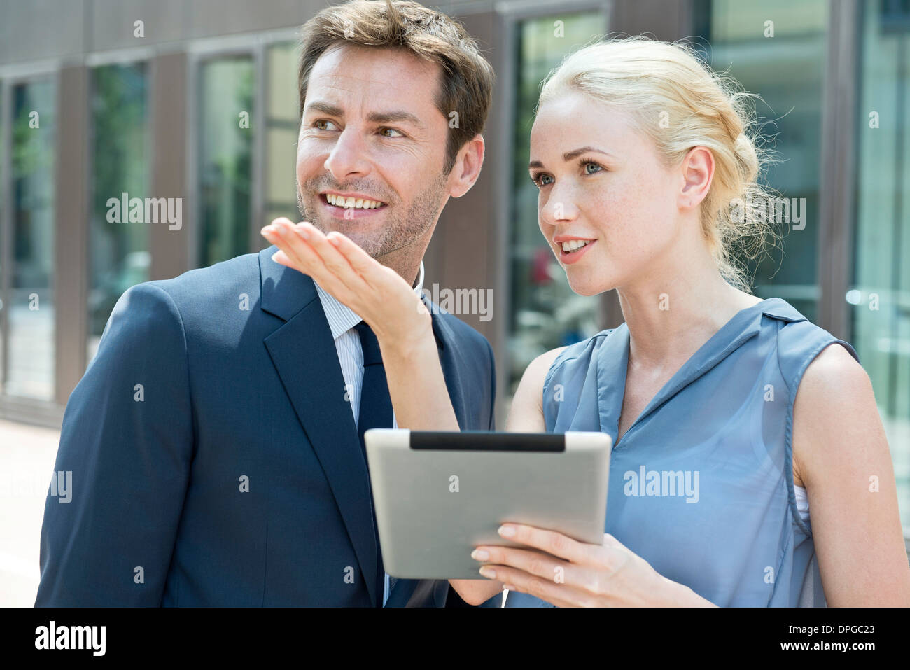 Real estate agent with digital tablet showing property to potential