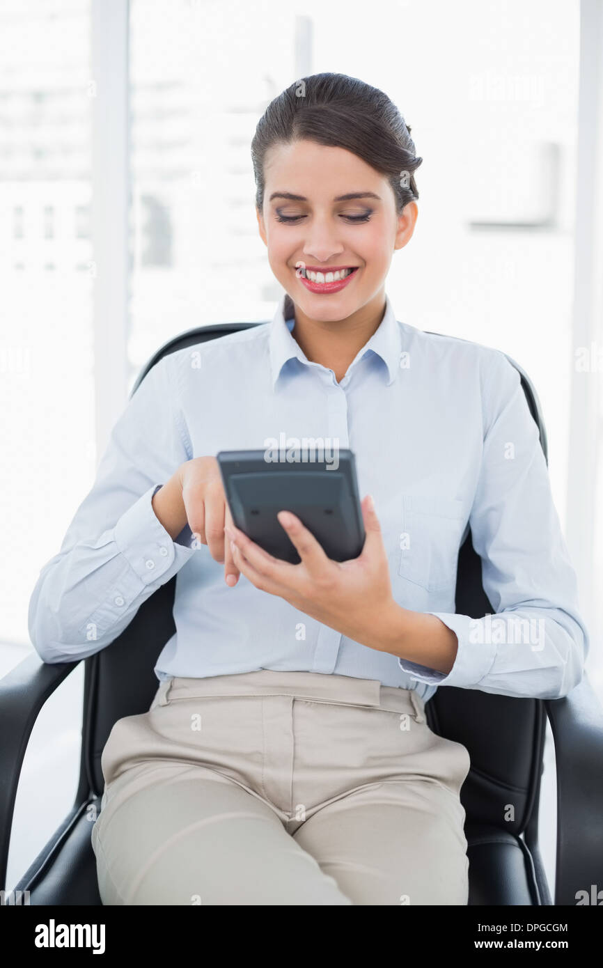 Content classy brown haired businesswoman using a calculator Stock Photo