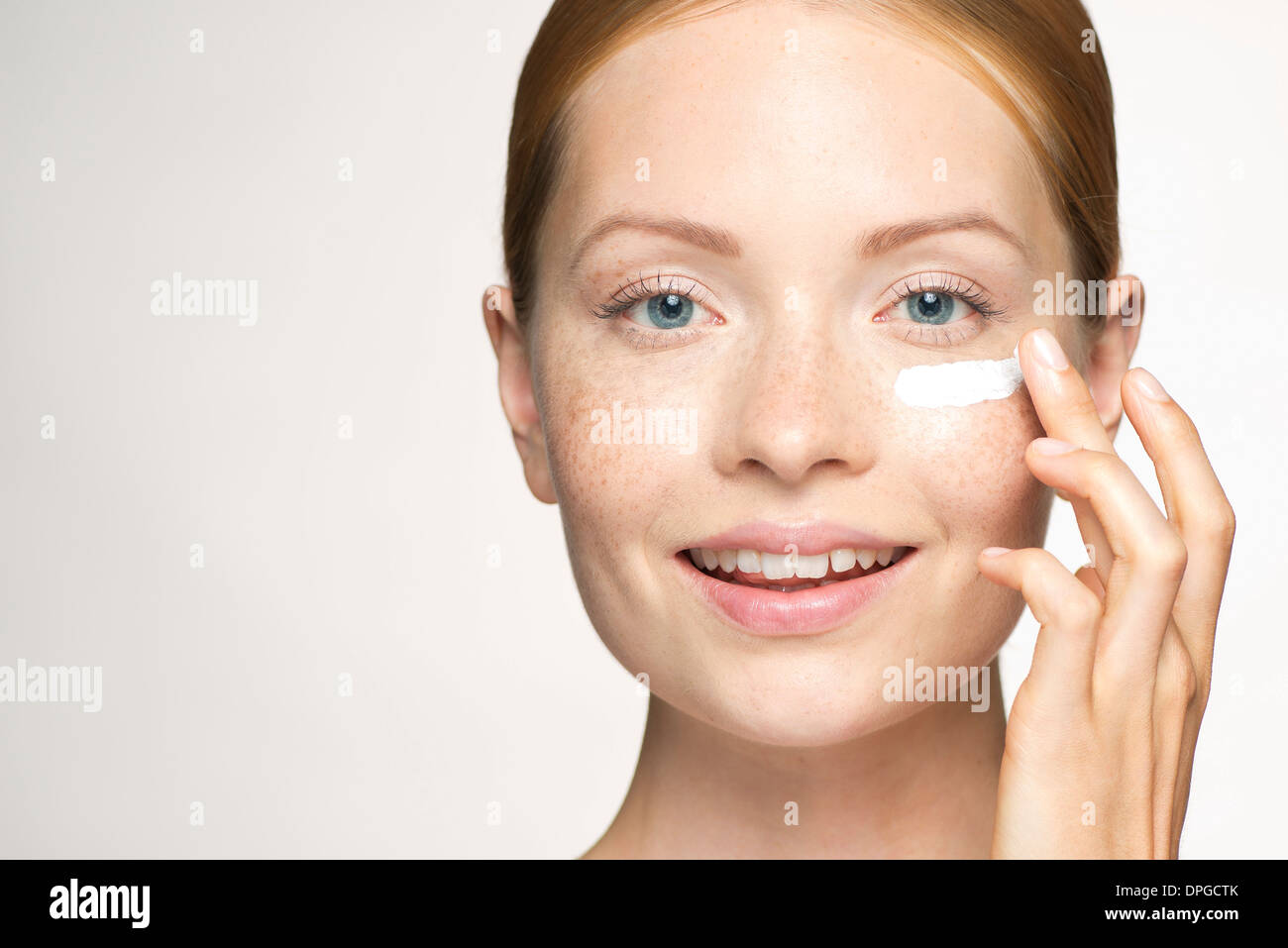 Young woman applying moisturizer under eye Stock Photo Alamy