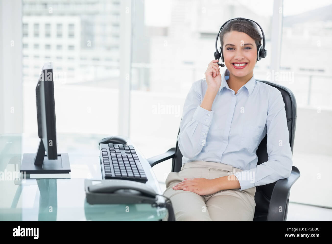 Smiling classy brown haired operator answering a call Stock Photo