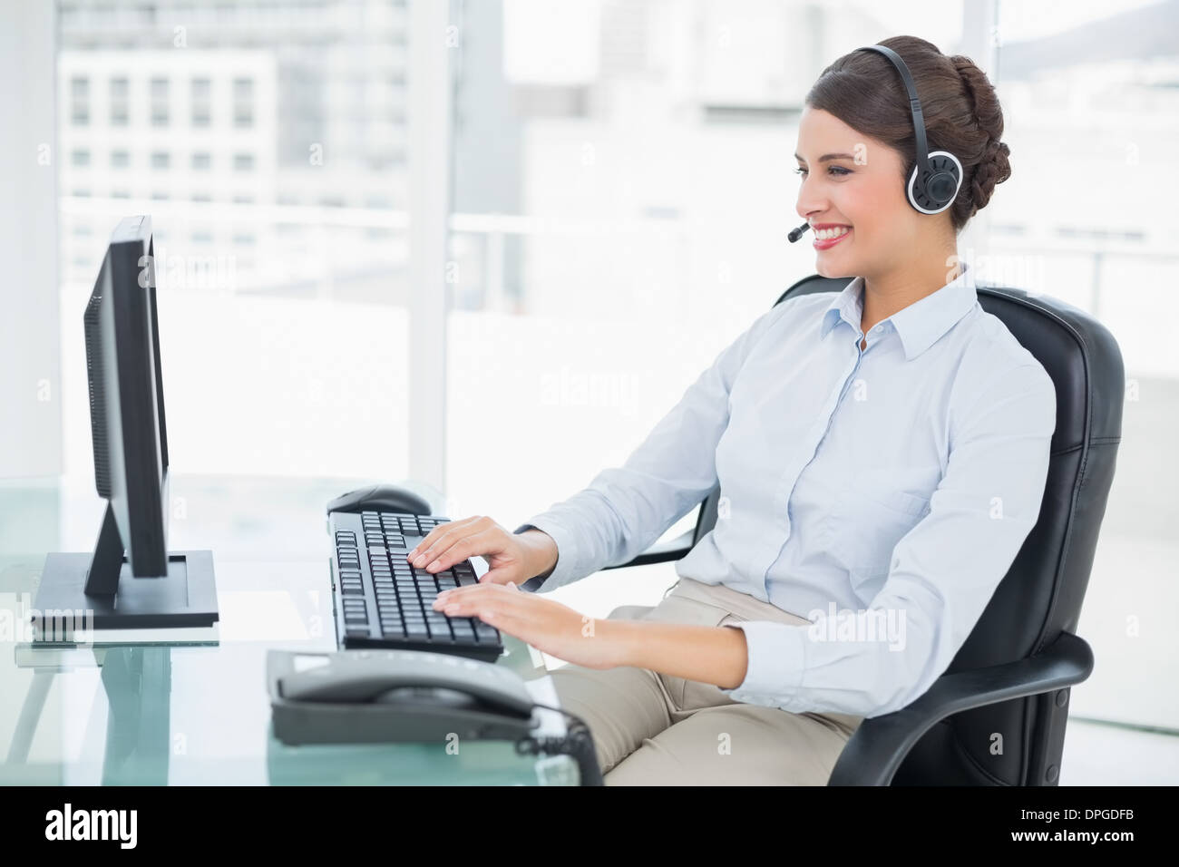 Cheerful classy brown haired operator using her computer Stock Photo