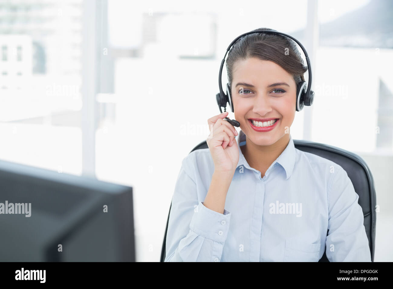 Beautiful classy brown haired operator answering a call Stock Photo