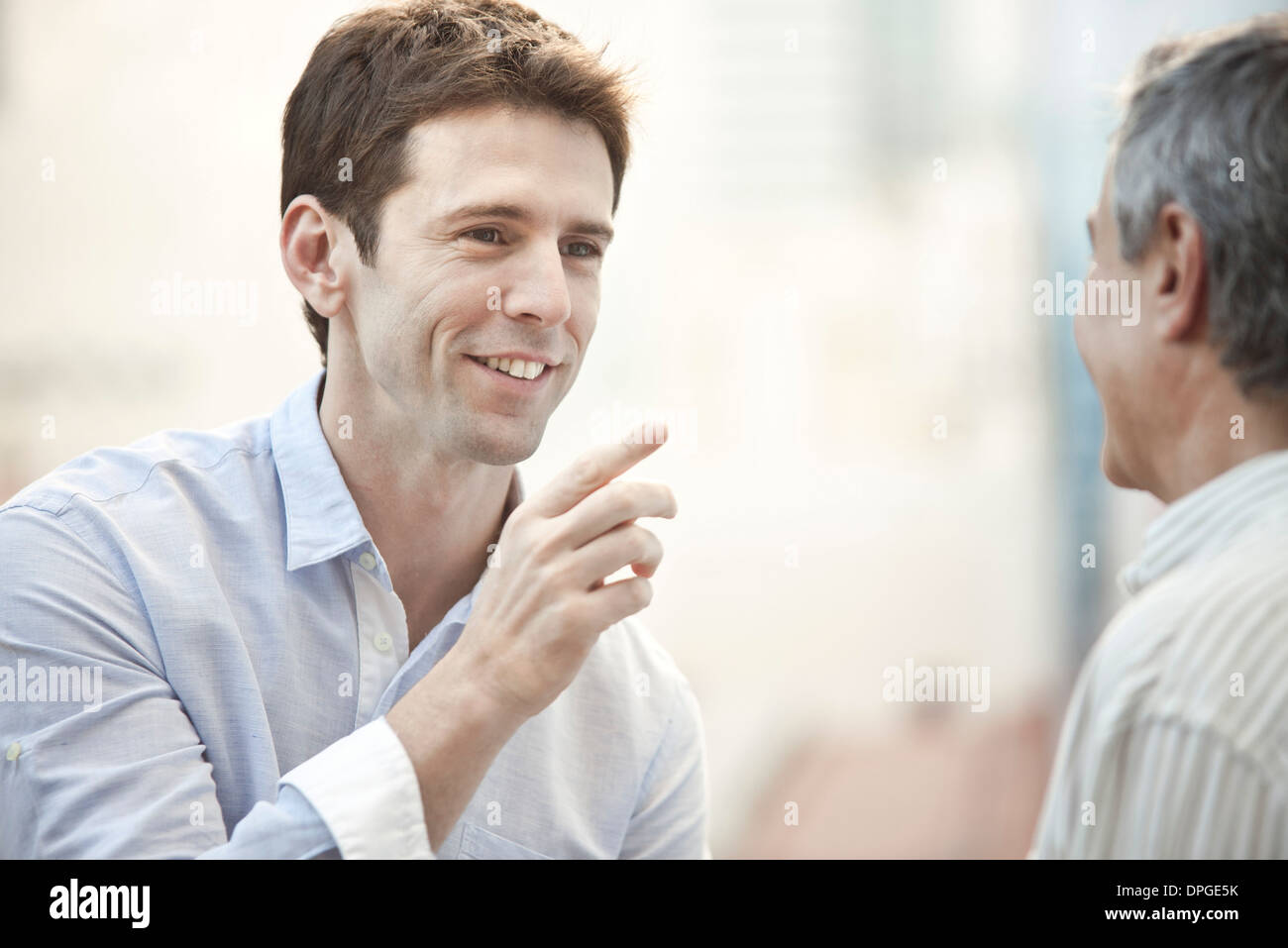 Mid-adult man talking with friend Stock Photo
