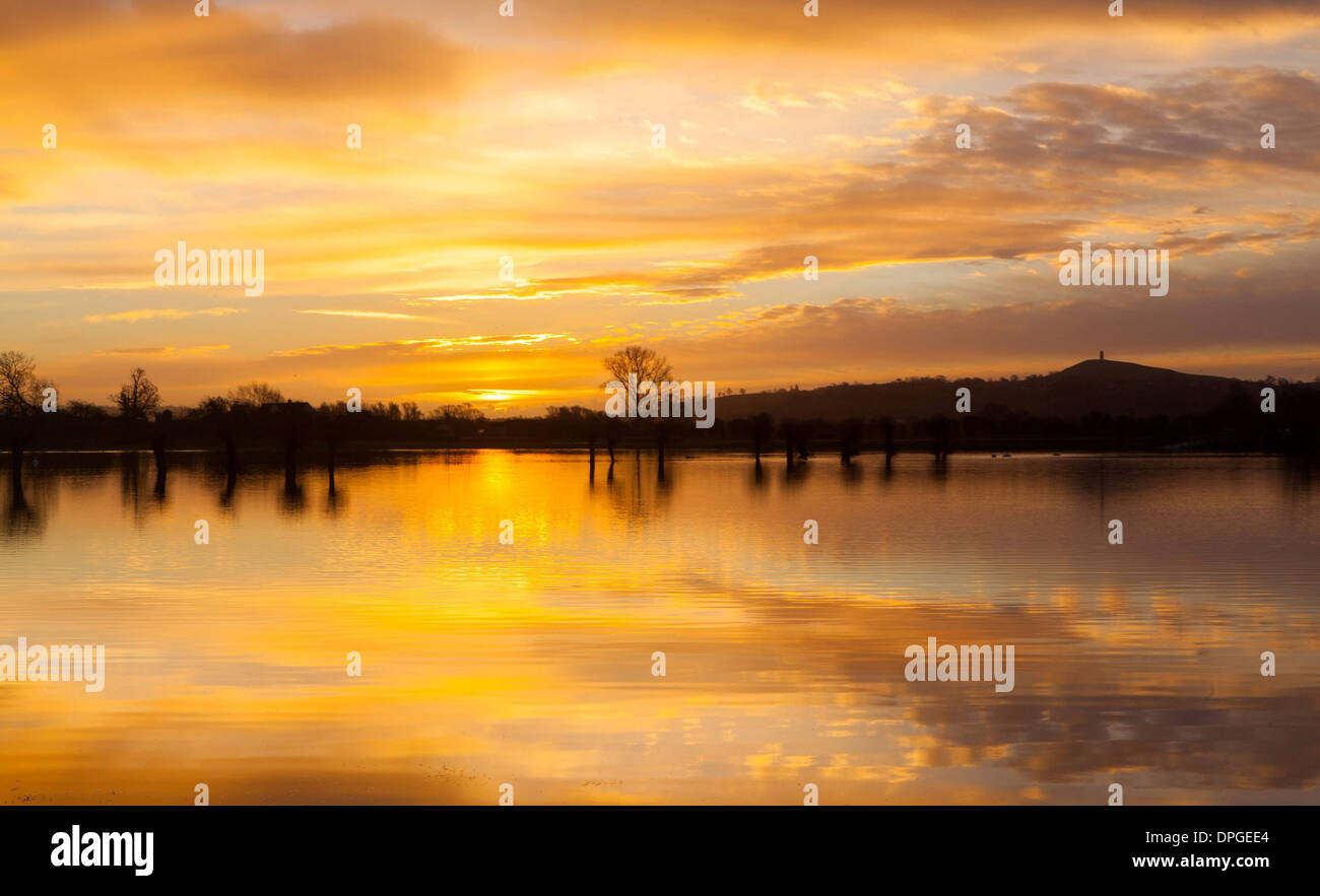 Glastonbury Tor can be seen during a stunning sunrise over flooded fields Stock Photo