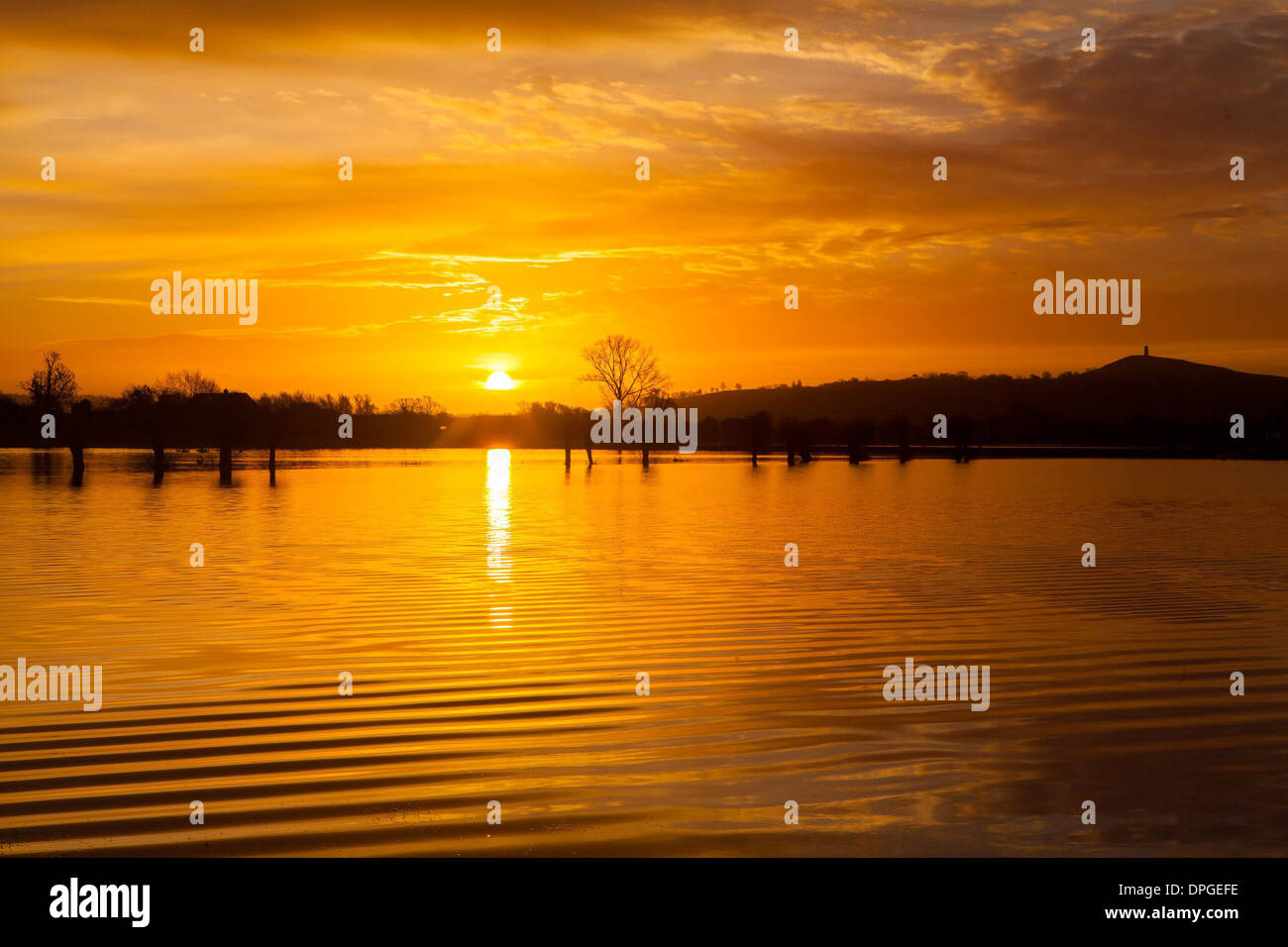 Glastonbury Tor can be seen during a stunning sunrise over flooded fields Stock Photo