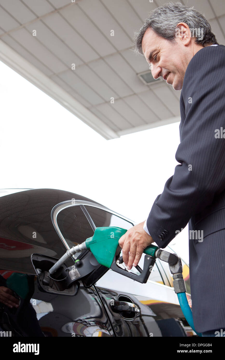 Businessman refueling car at gas station Stock Photo