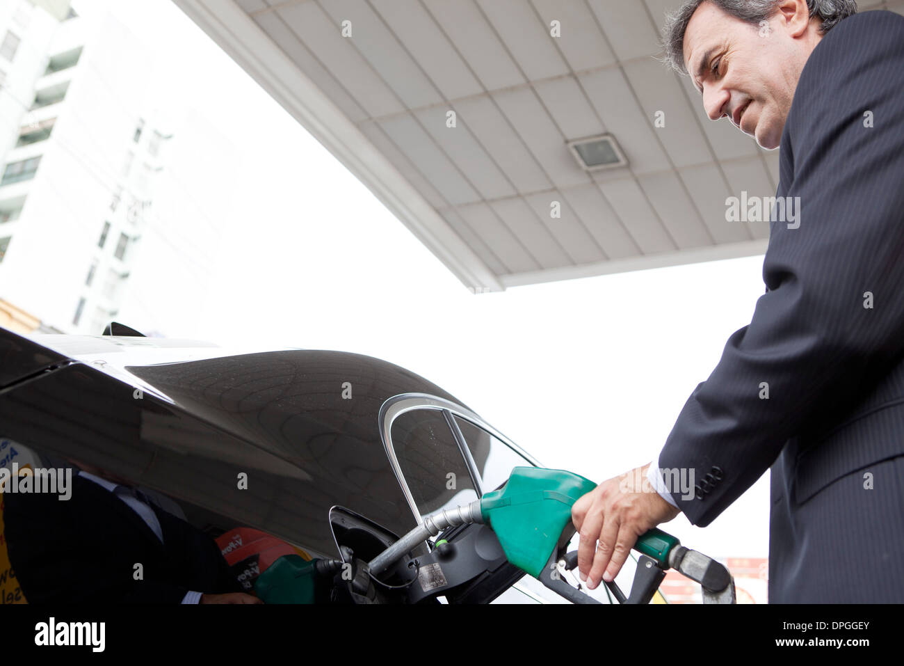 Businessman refueling car at gas station Stock Photo