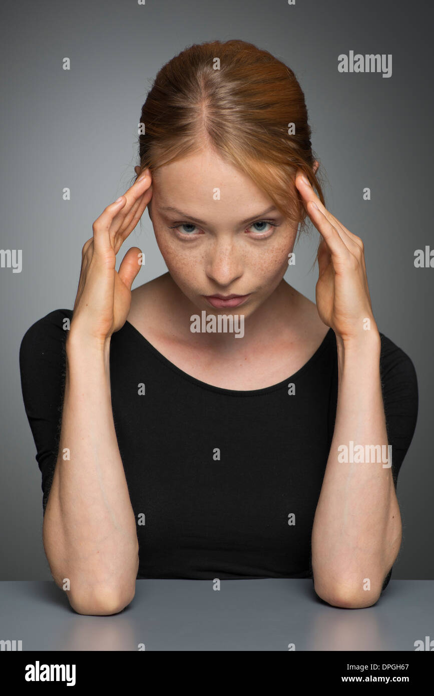 Young woman holding head, portrait Stock Photo