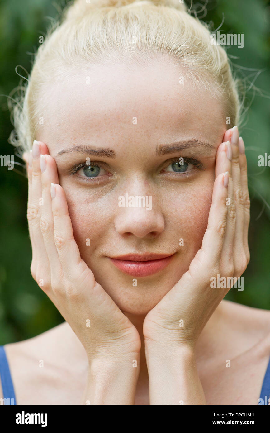 Young woman with hands under chin Stock Photo