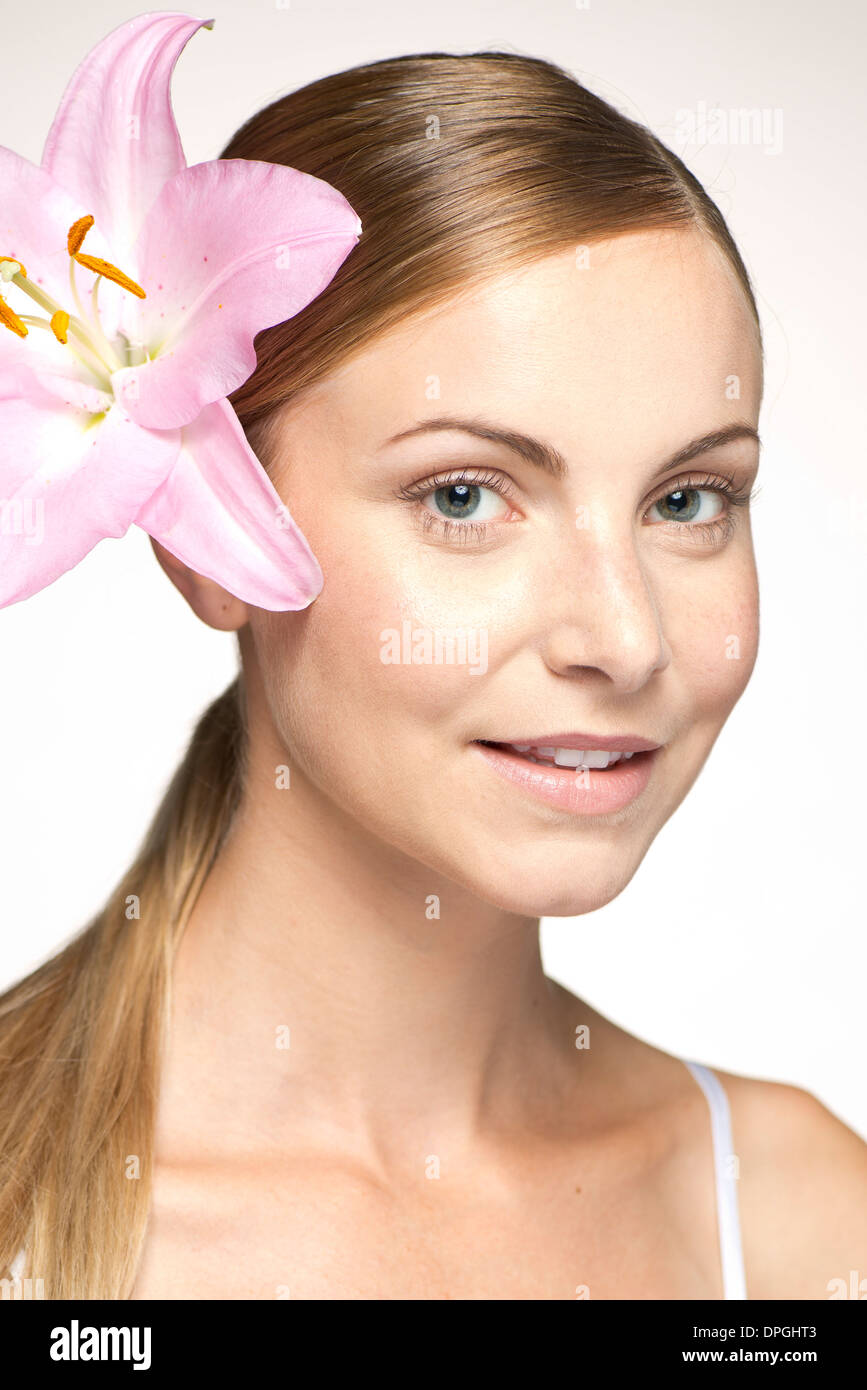 Young woman wearing lily in hair, portraitwearing Stock Photo