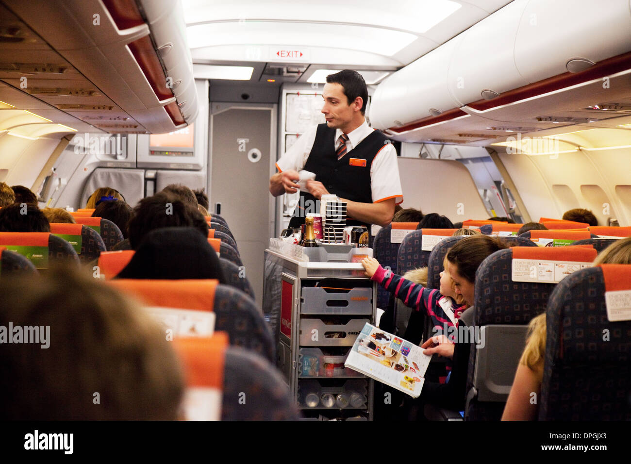 Easyjet cabin crew: Easyjet airline flight attendant staff in the plane serving food and drinks as a meal for passengers Stock Photo