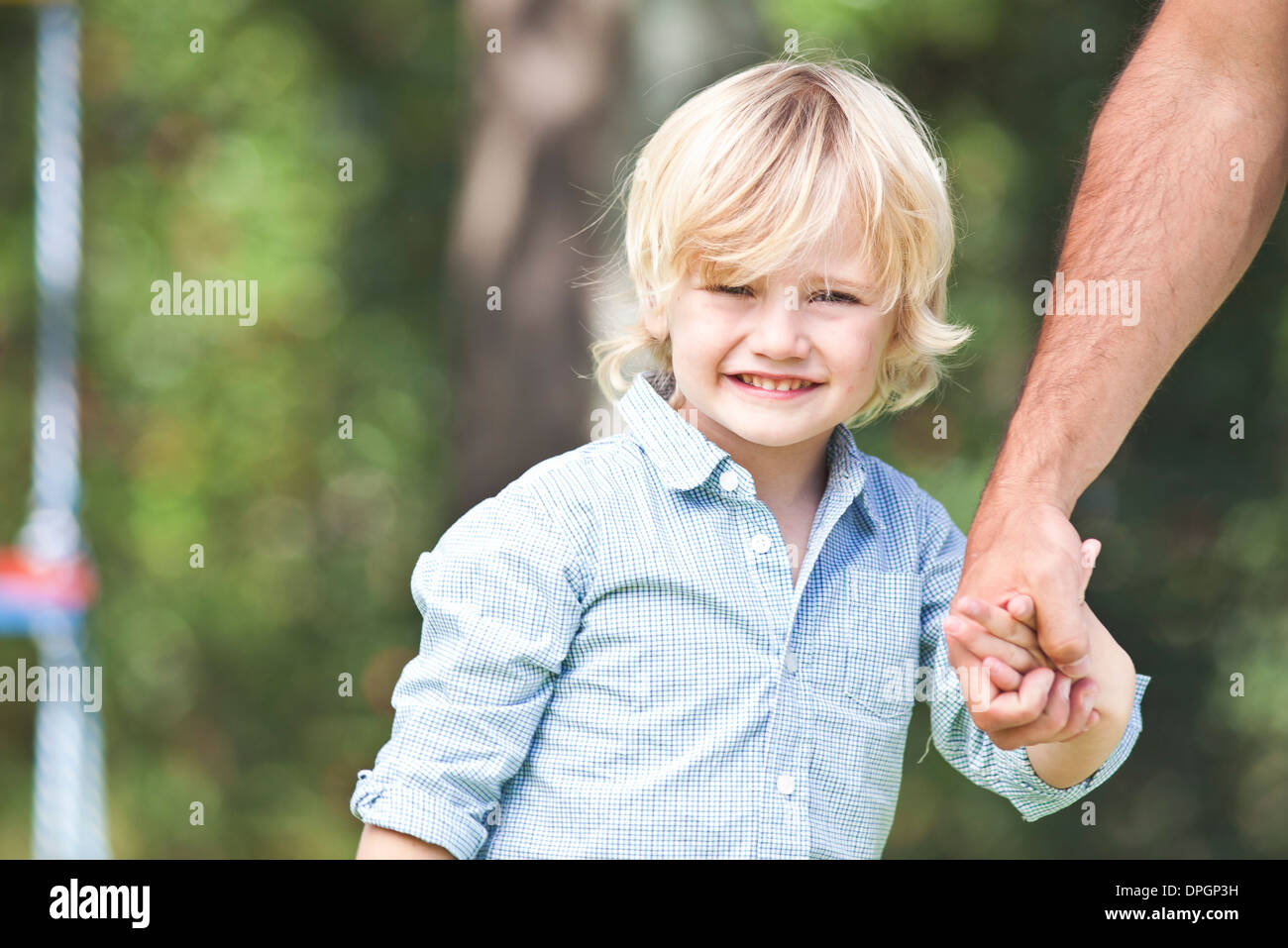 Little boy holding father's hand Stock Photo