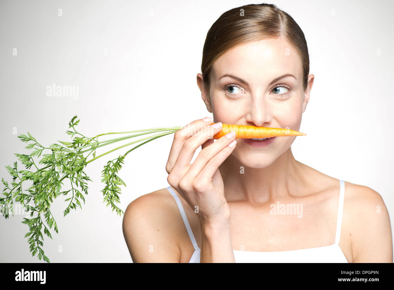 Young woman smelling carrot Stock Photo
