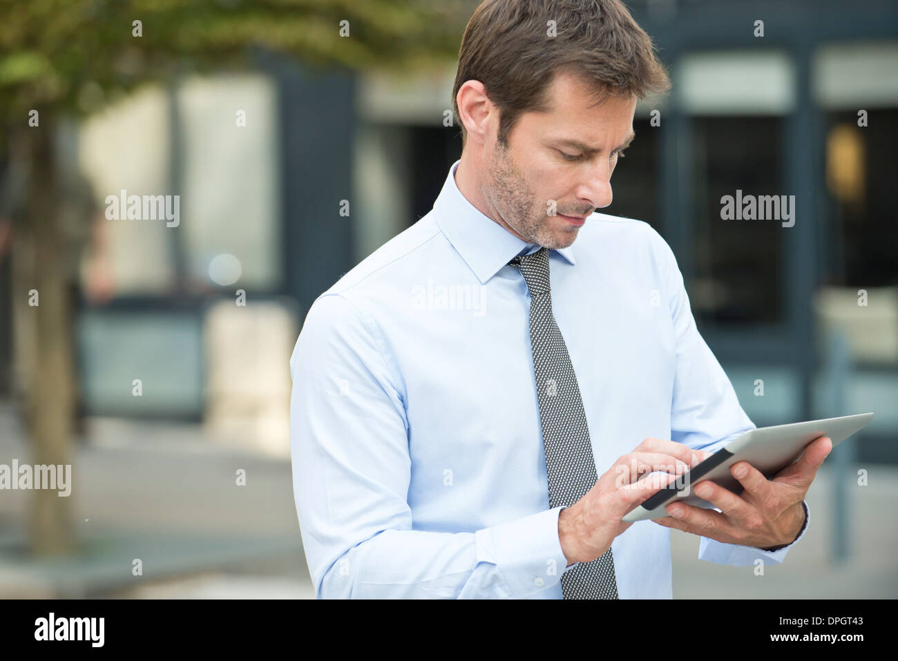 Businessman using digital tablet outdoors Stock Photo