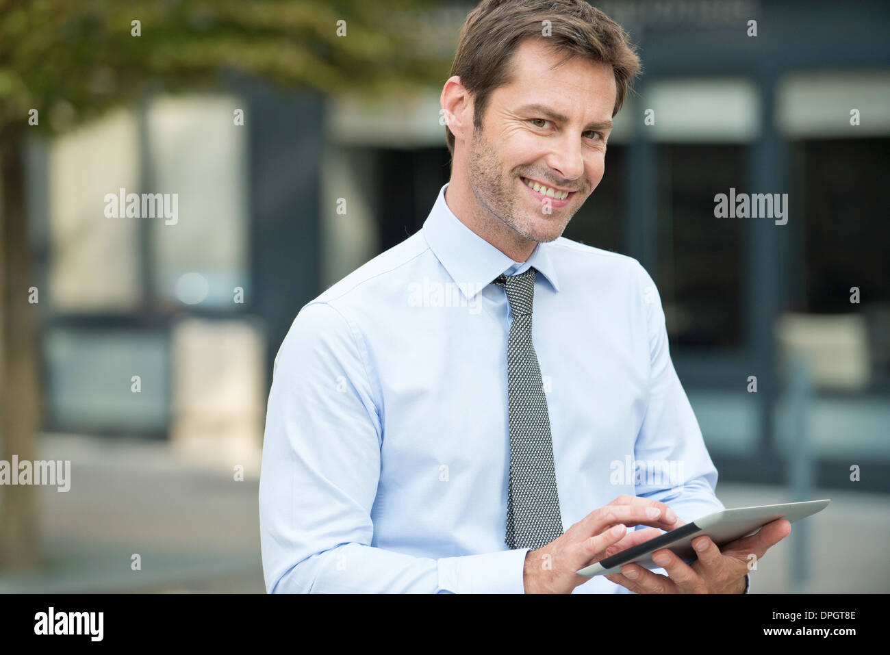 Businessman using digital tablet outdoors Stock Photo
