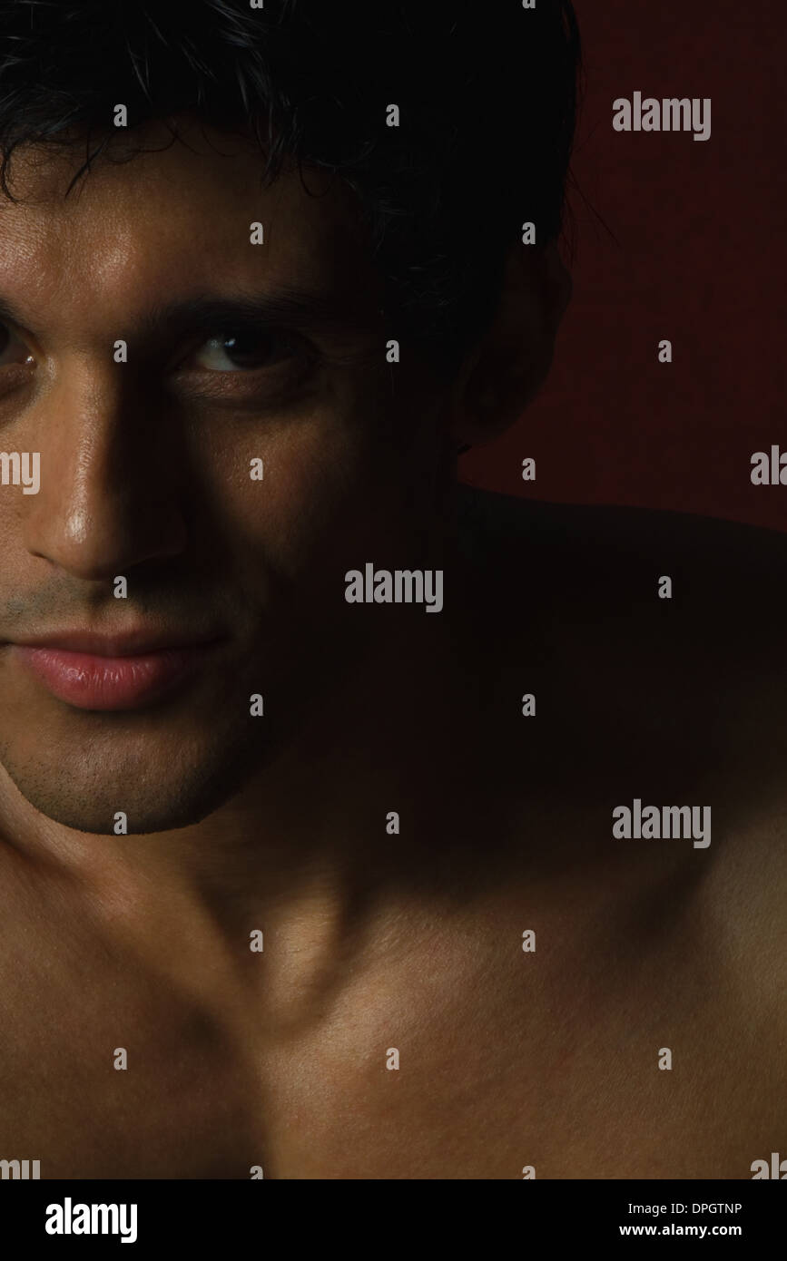 Barechested man looking at camera, close-up of face and chest Stock Photo