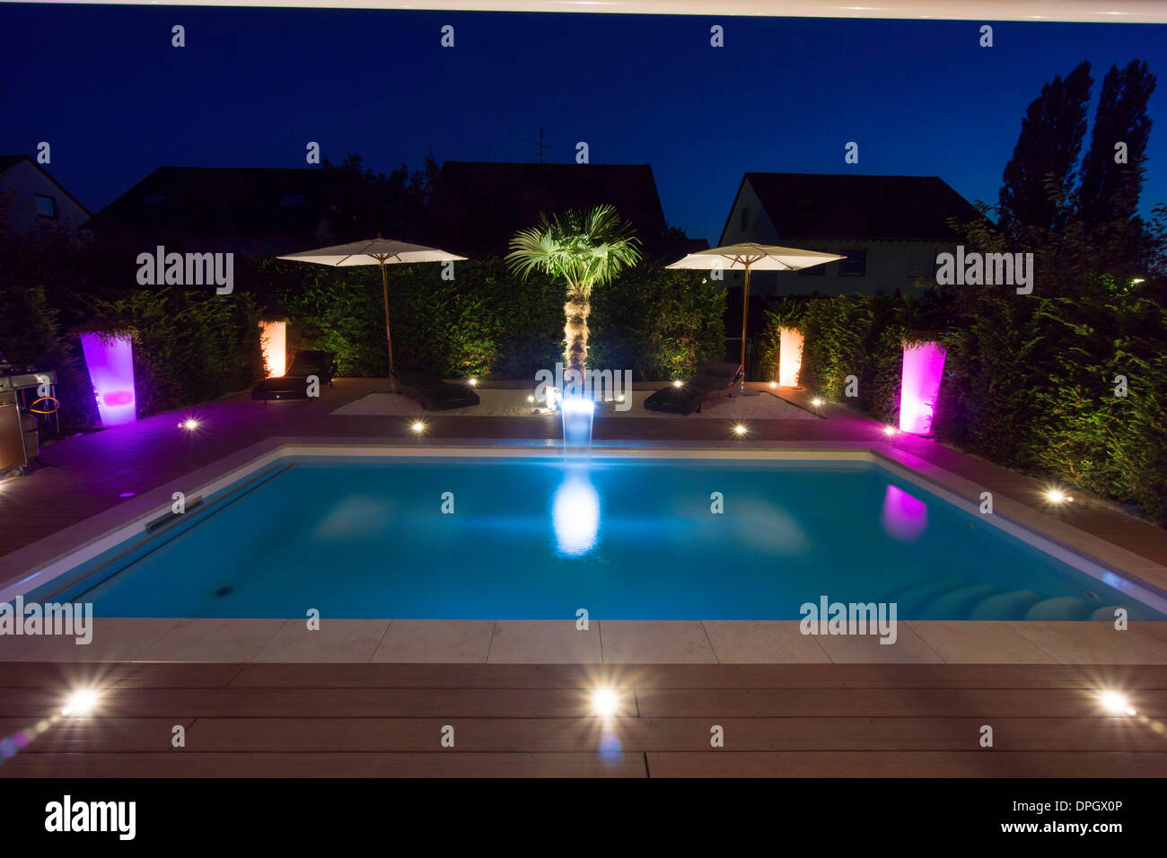 Private garden with pool and terrace and palm with show lighting at night in summer, Germany, Europe - August 2013. Stock Photo