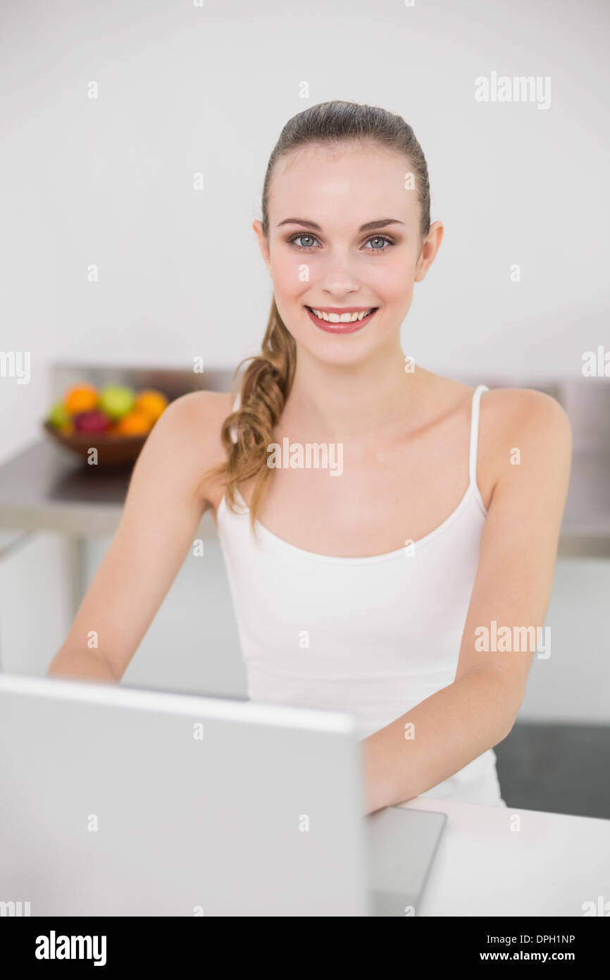 Cheerful young woman using her laptop Stock Photo