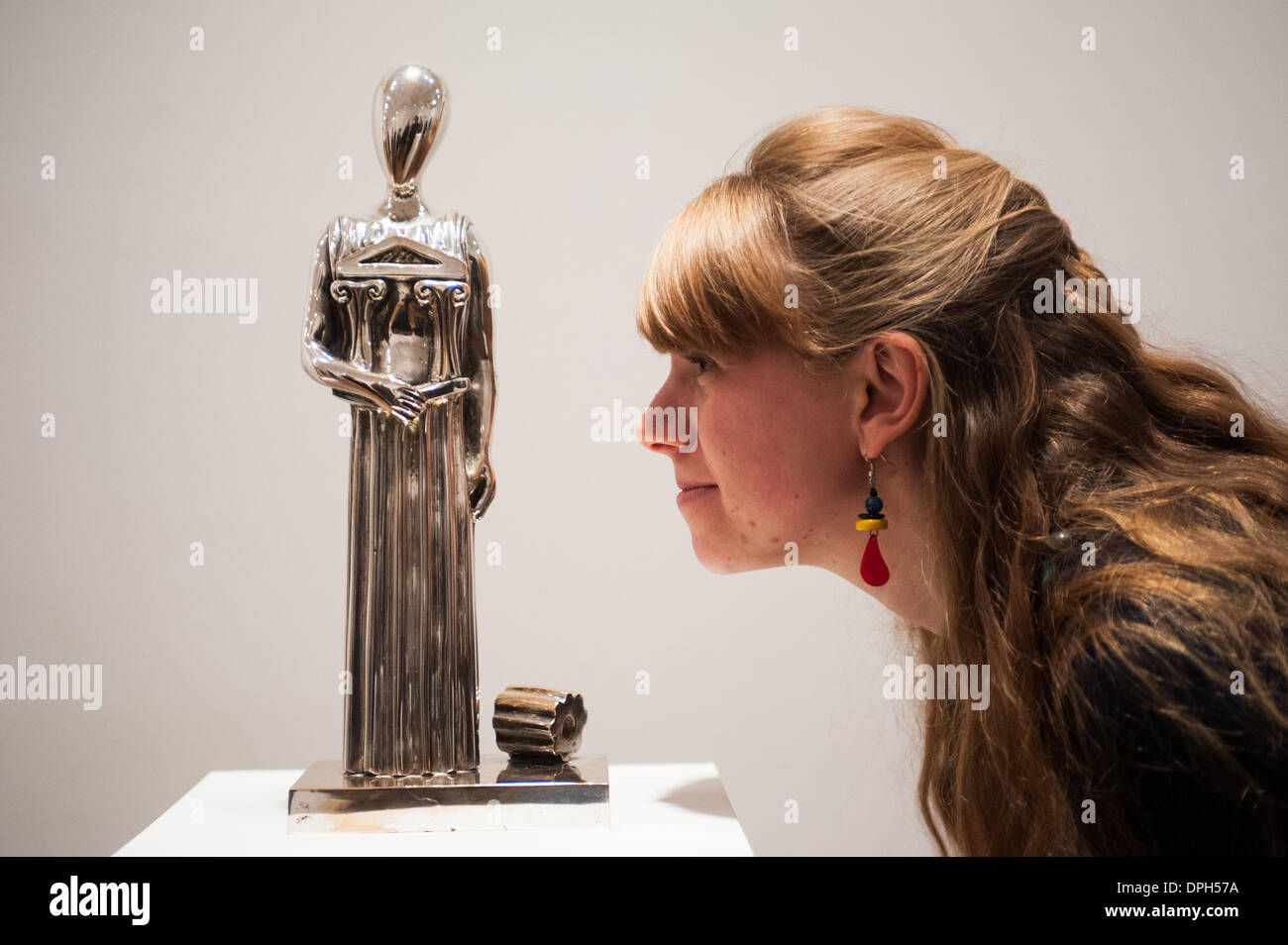 London, UK - 14 January 2014: a member of staff of the Estorick Collection of Modern Italian Art looks at a silvered bronze sculpture entitled 'Architecture Muse, 1974' at the Giorgio de Chirico: Myth and Mystery exhibition that opens tomorrow and runs until the 19 April 2014. Credit:  Piero Cruciatti/Alamy Live News Stock Photo
