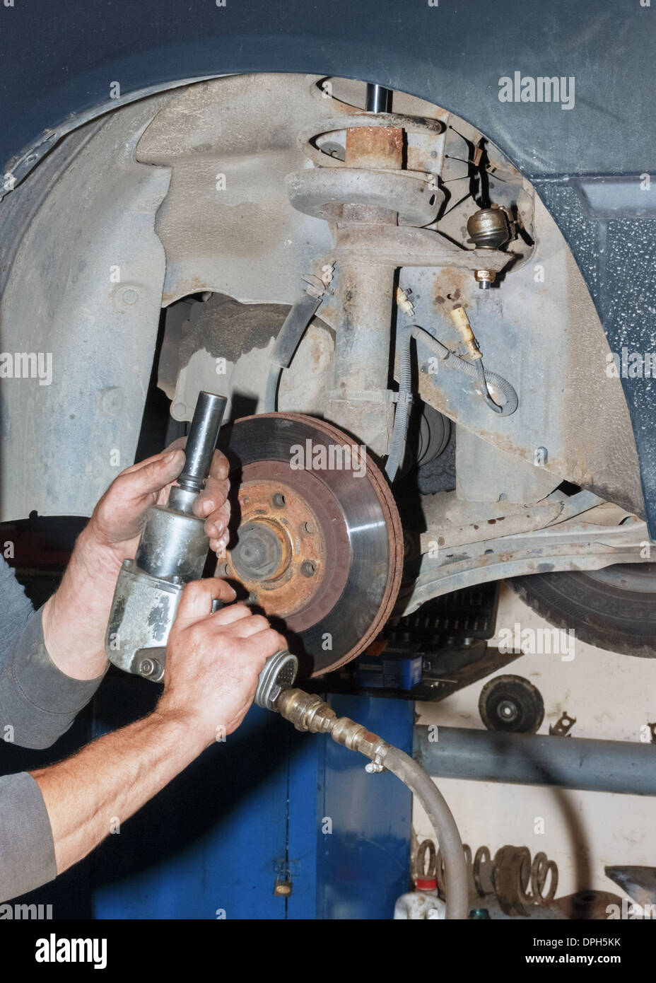 Auto mechanic working on a car in garage Stock Photo - Alamy