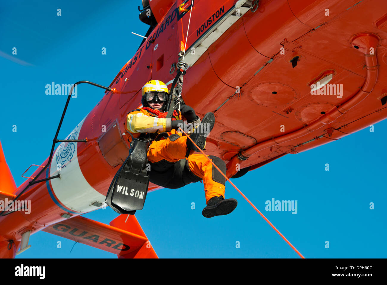 US Coast Guard Petty Officer 3rd Class Andrew Wilson, a rescue swimmer with Air Station Houston is lowered to a small boat in Galveston Bay during training January 9, 2014 in Galveston, Texas. Stock Photo