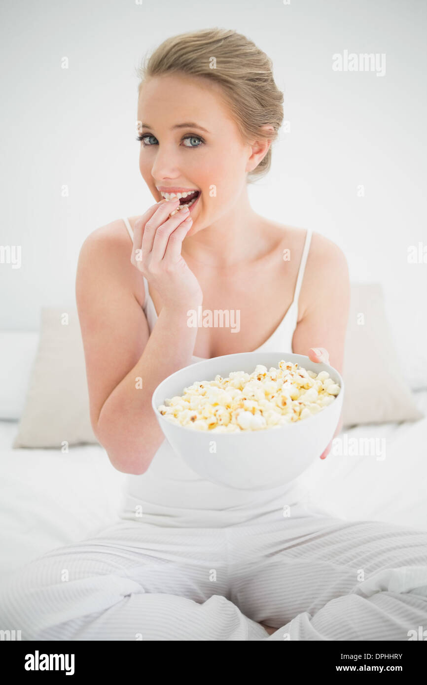 Natural happy blonde eating popcorn on bed Stock Photo Alamy