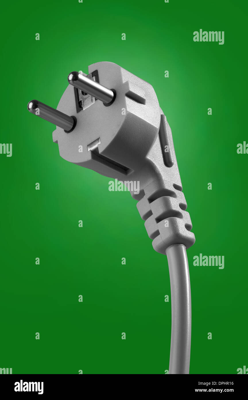 electrical cable with plug on green background Stock Photo - Alamy