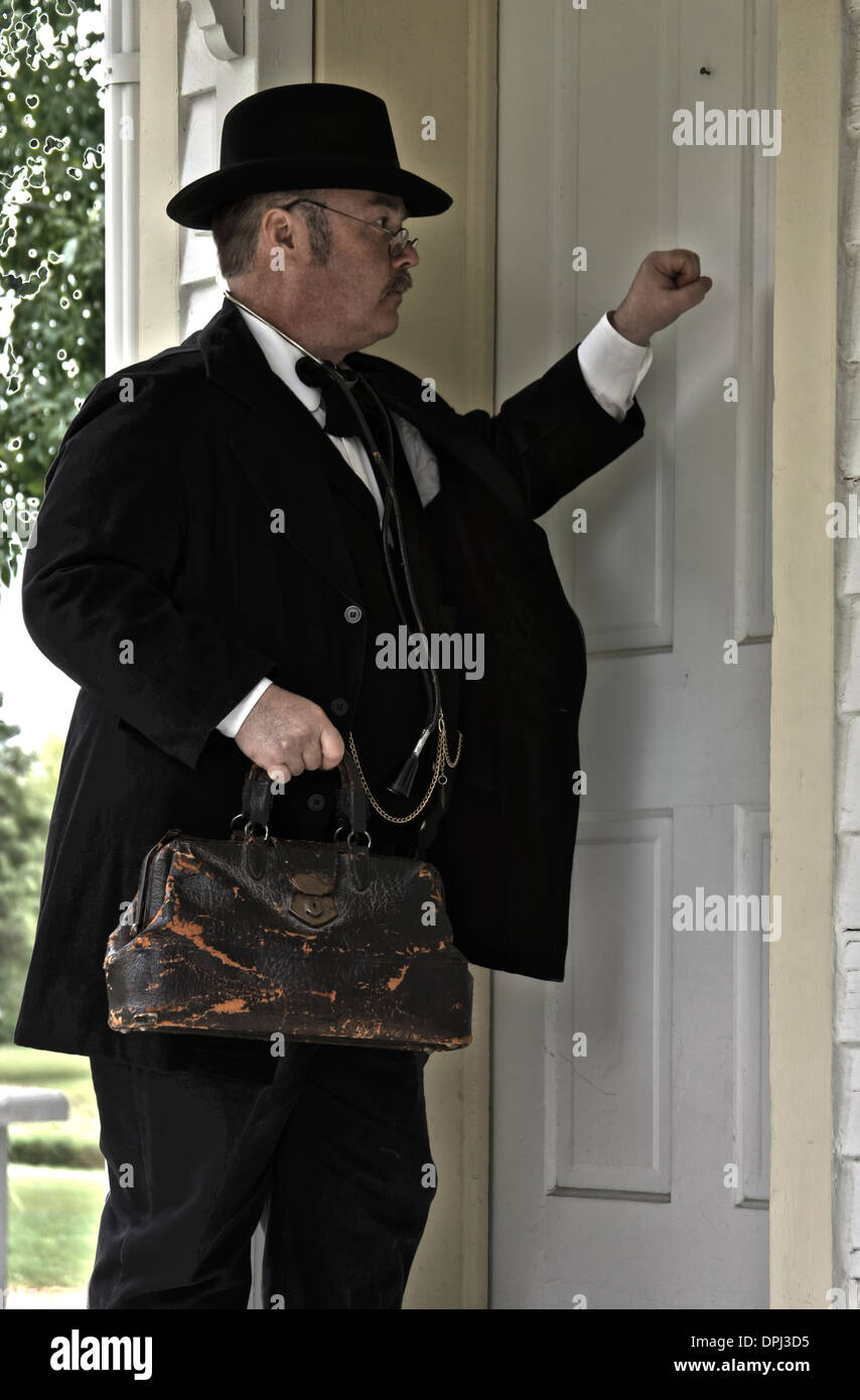Old time doctor knocking on a front door for a house call Stock Photo