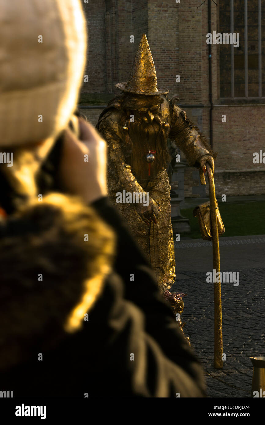 human gold wizard living statue tourist interacting with crowed tourists Stock Photo