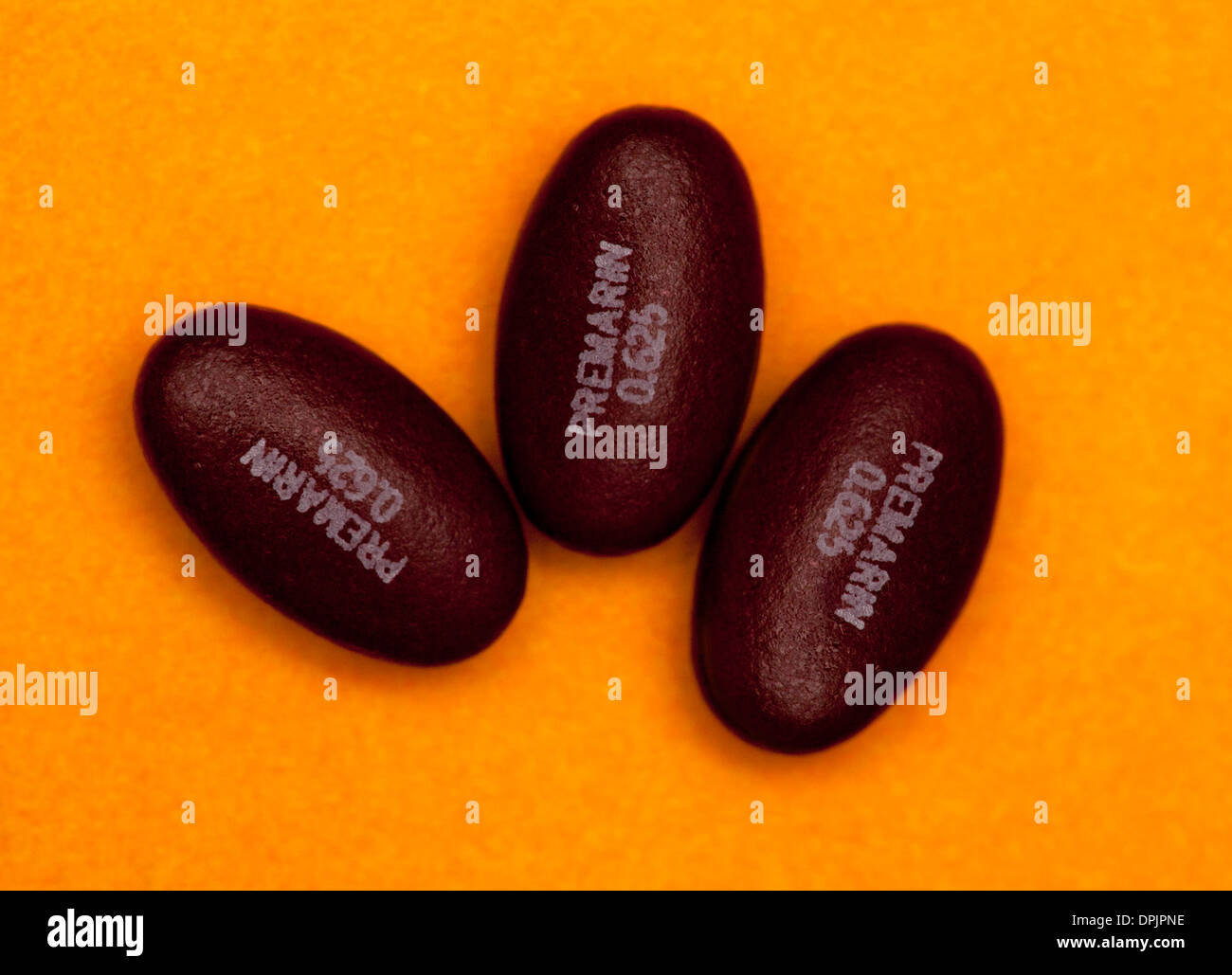 Four Premarin pills, used for estrogen hormone replacement therapy. Stock Photo