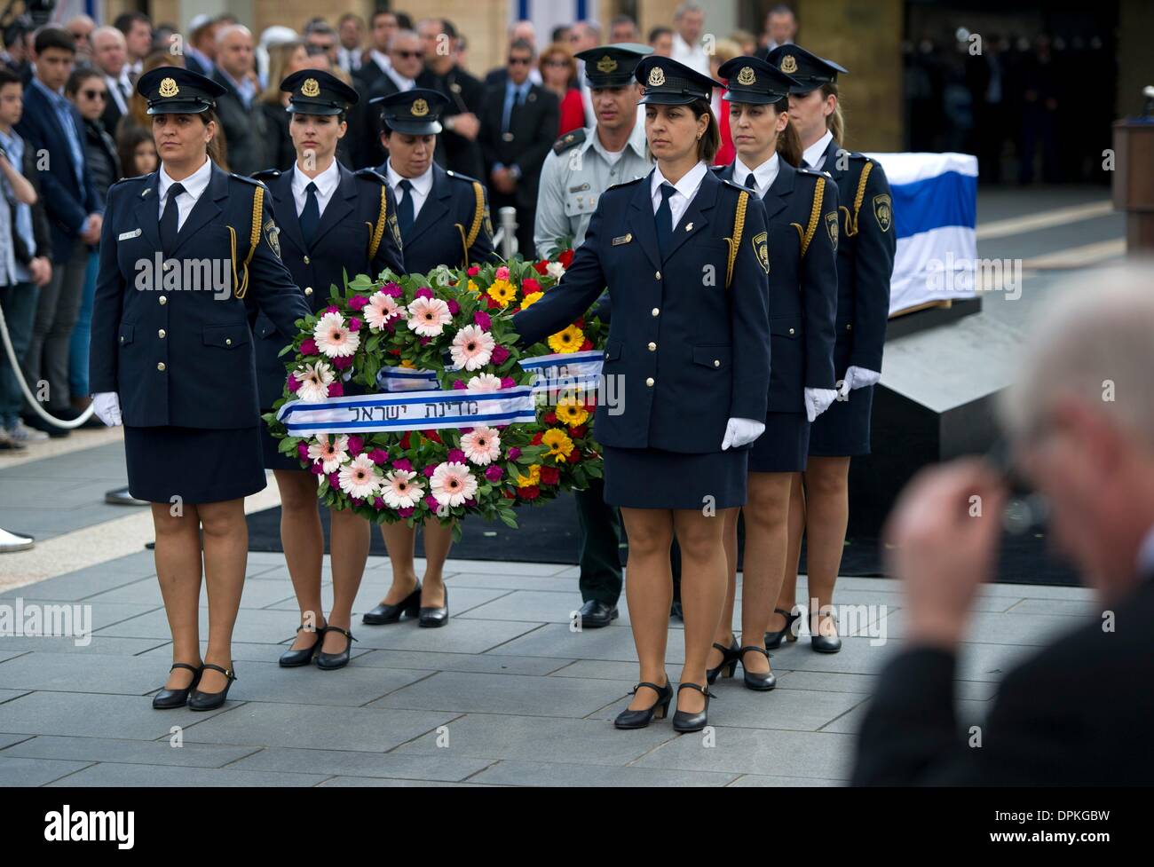 Jerusalem, Israel. 13th Jan, 2014. Women in uniform carry funeral wreaths as they stand in front of the coffin of former Israeli Prime Minister Ariel Scharon, during the state funeral in Jerusalem, Israel, 13 January 2014. Photo: Daniel Naupold/dpa/Alamy Live News Stock Photo