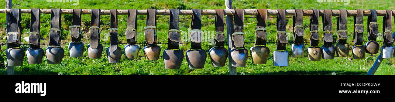group of cow bells in line on fence in Bavaria Stock Photo