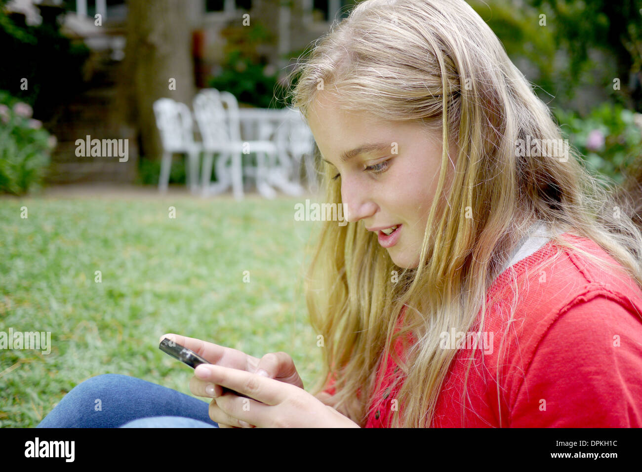 young girl types a text message Stock Photo