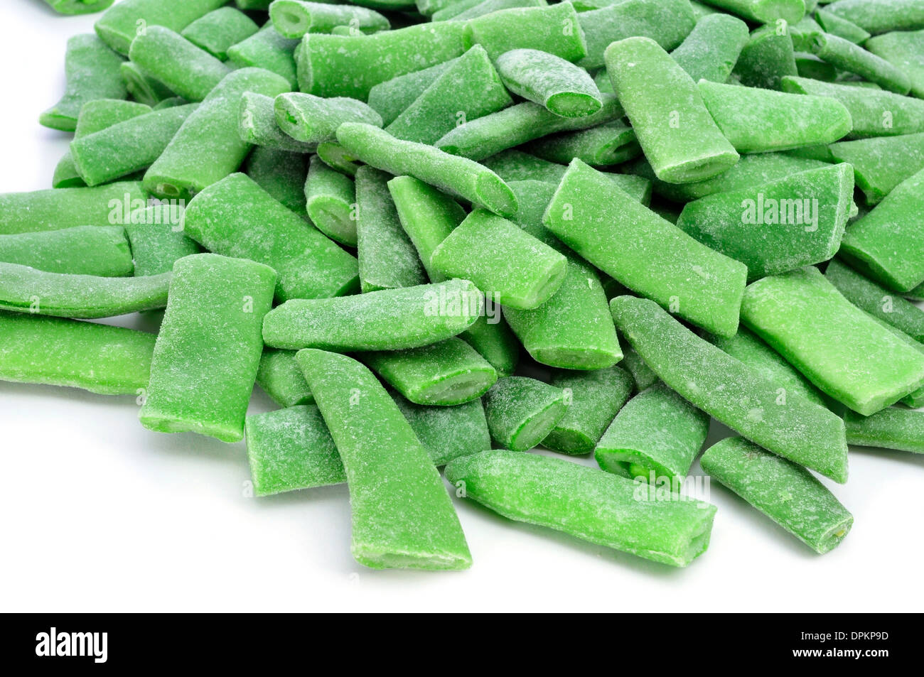 closeup of a pile of frozen chopped green beans on a white background Stock Photo