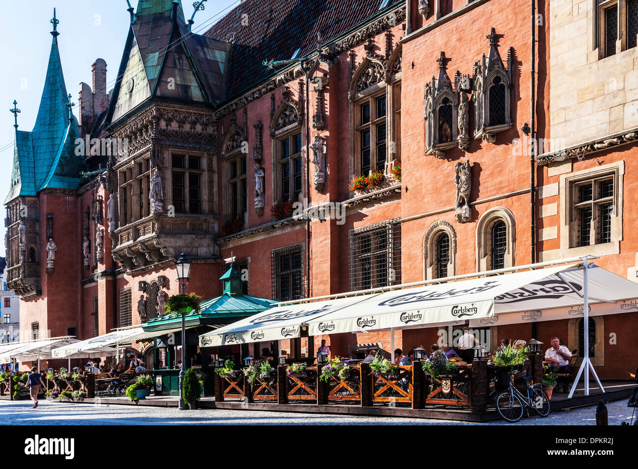 Outdoor restaurant bar beneath the neo-Gothic Town Hall or Ratusz in Wroclaw's market Square. Stock Photo