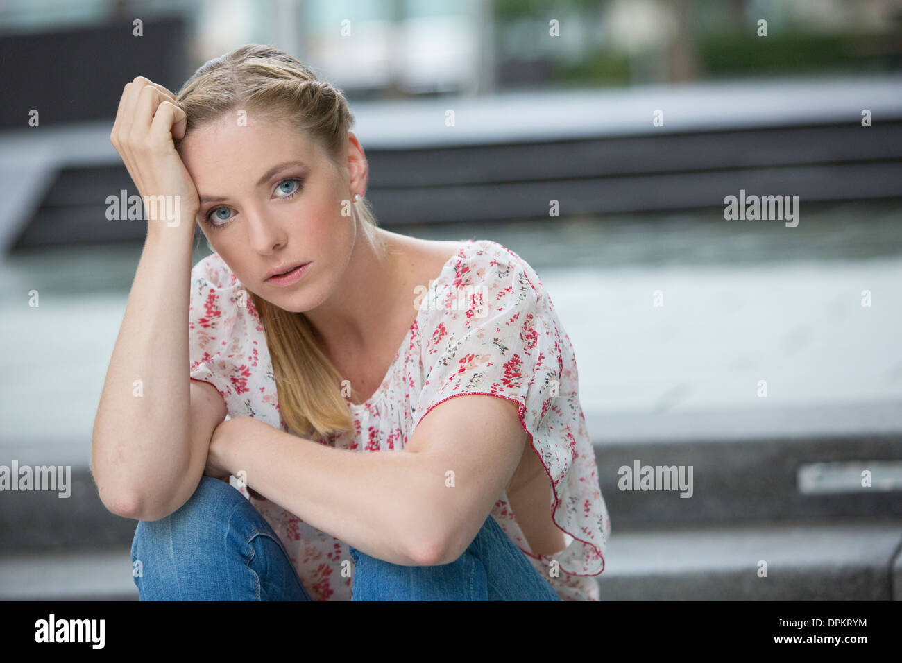 Portrait of young woman sitting on stairs Stock Photo