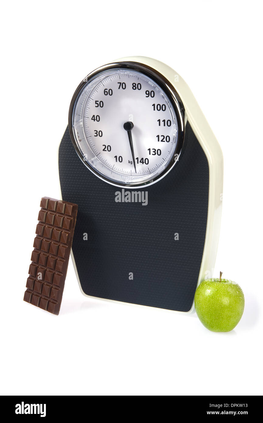 A weight scale with chocolate and an apple Stock Photo