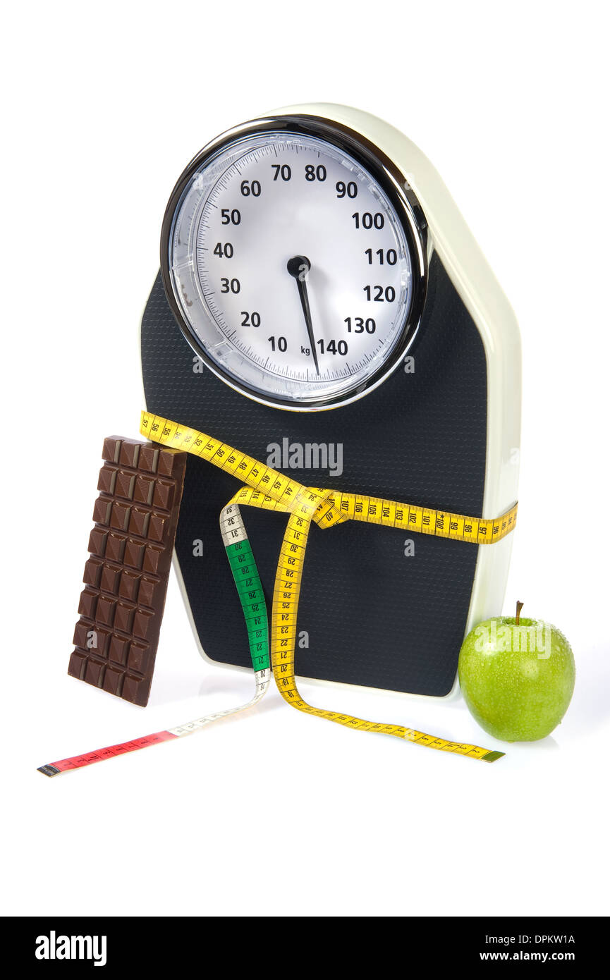 A scale with measuring tape, chocolate and an apple Stock Photo